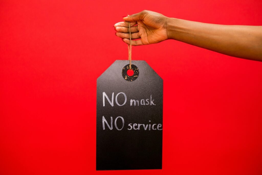 pexels-photo-7564258-7564258 A Person Holding a Sign Board No Mask No Service